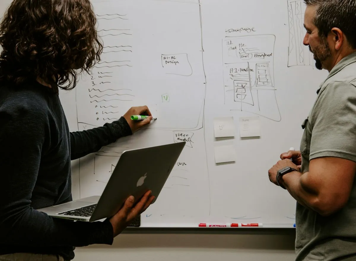 Engineers planning a system on a shared whiteboard.